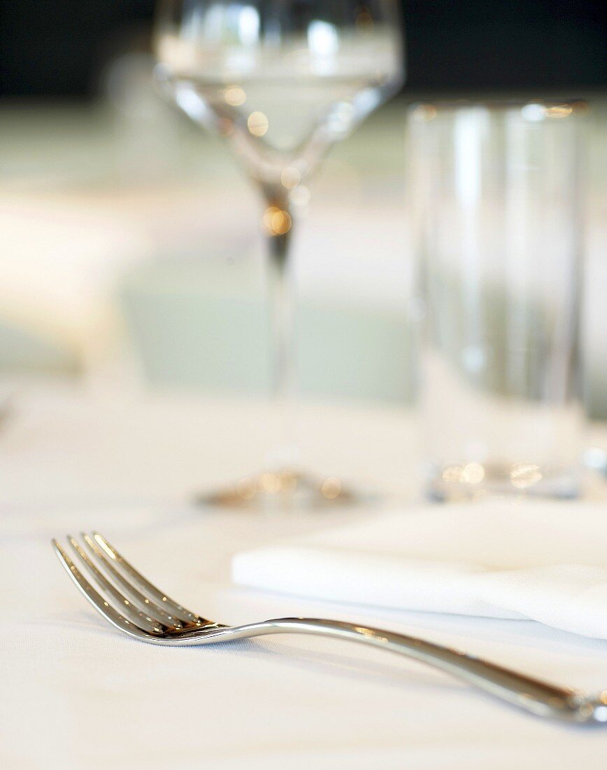Eine Gabel mit Serviette und Weinglas auf einem Tisch