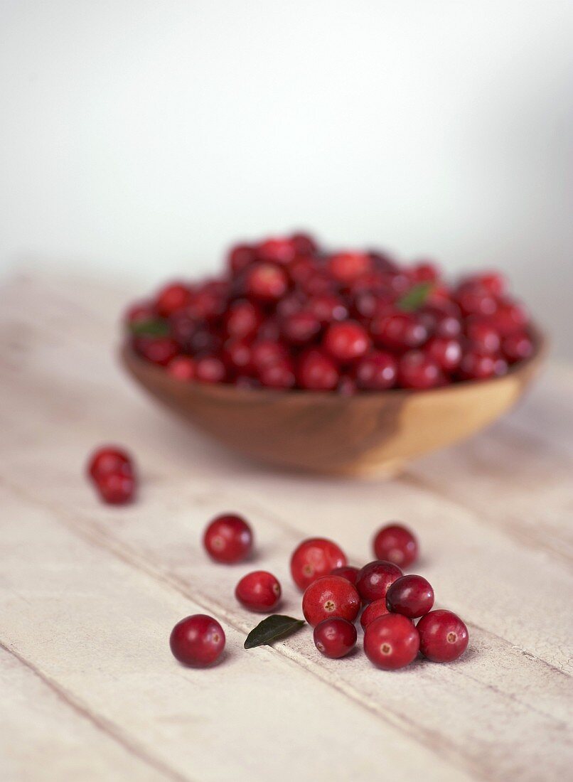 Cranberries in and in front of a small bowl