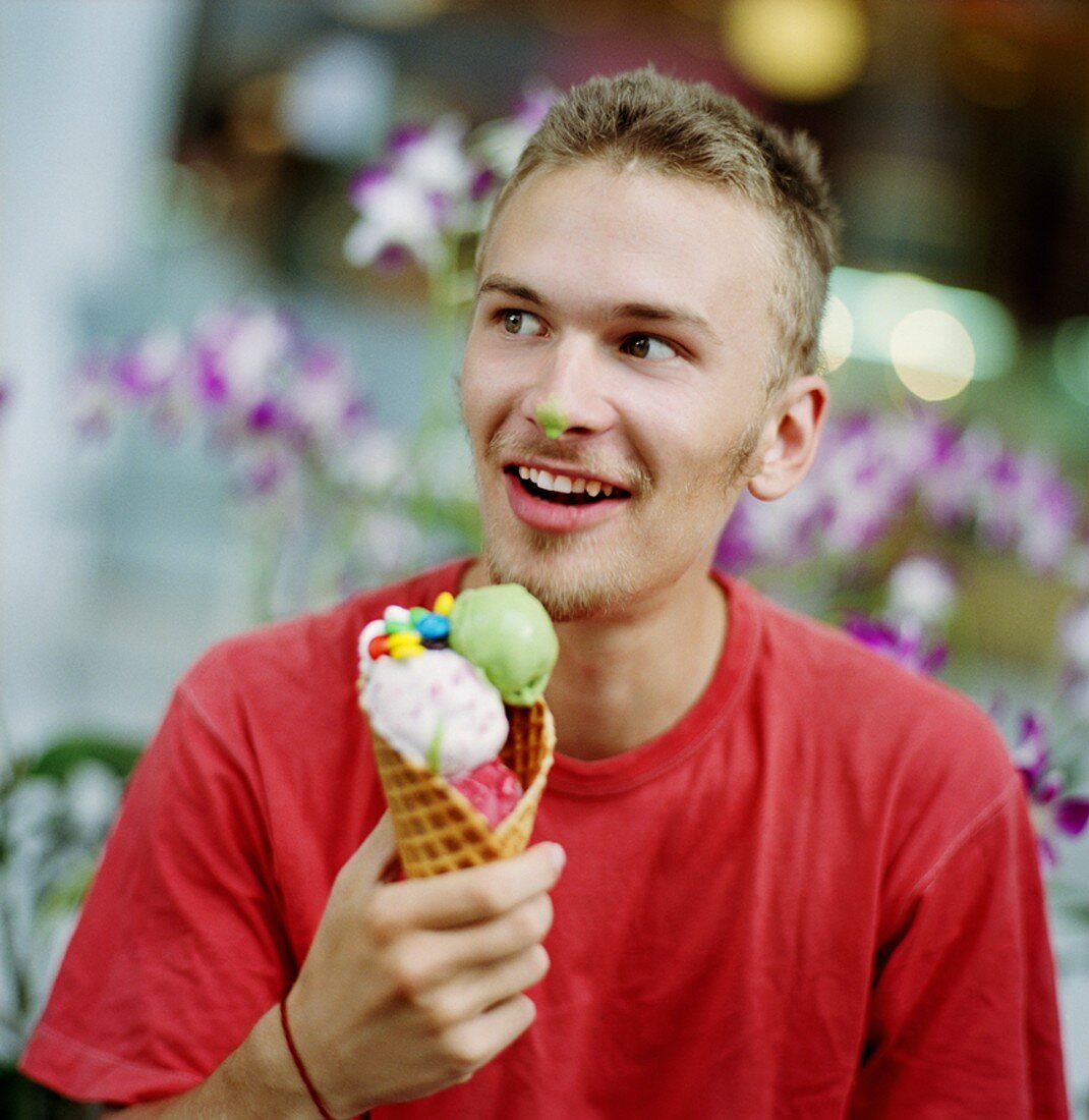 Junger Mann mit bunter Eistüte