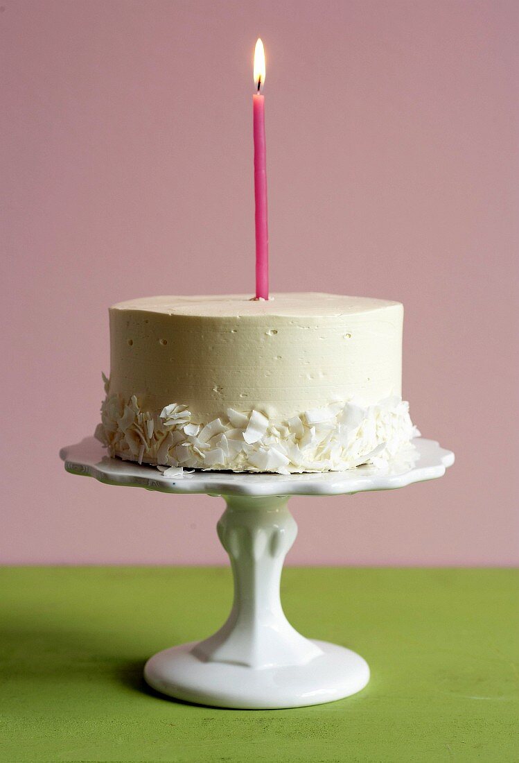 Cake with one candle on a cake stand