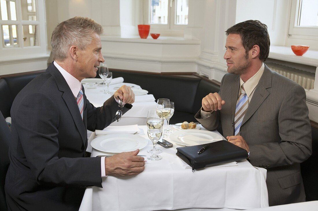 Two businessmen in conversation in a restaurant