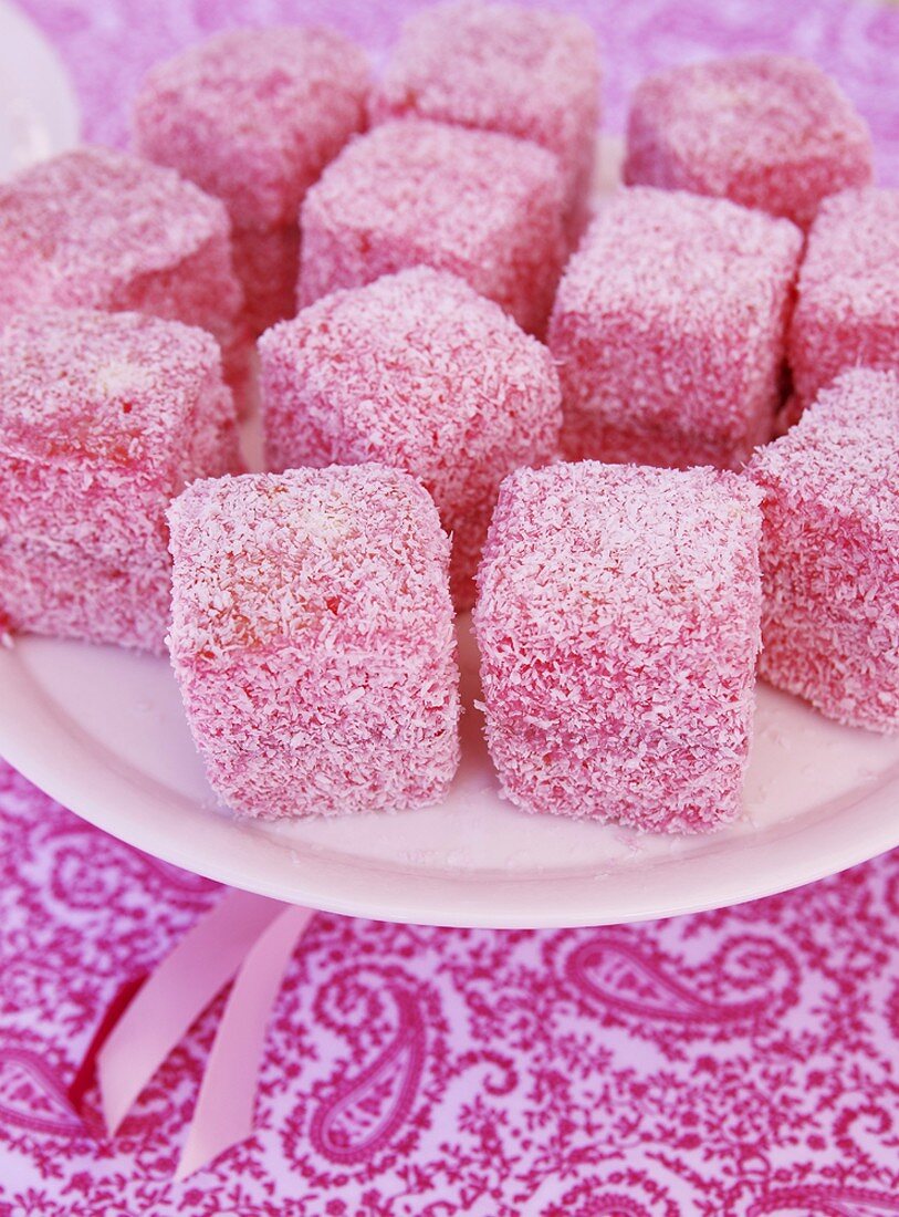 Lamingtons coated in pink icing and desiccated coconut
