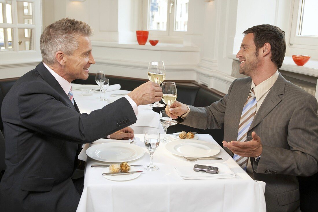 Zwei Männer trinken gemeinsam ein Glas Weißwein
