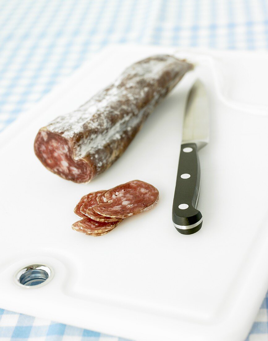 An Italian salami, partly sliced