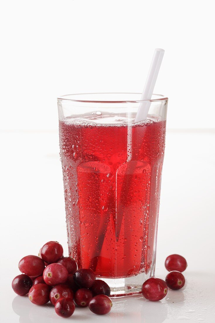 A glass of cranberry juice with a straw