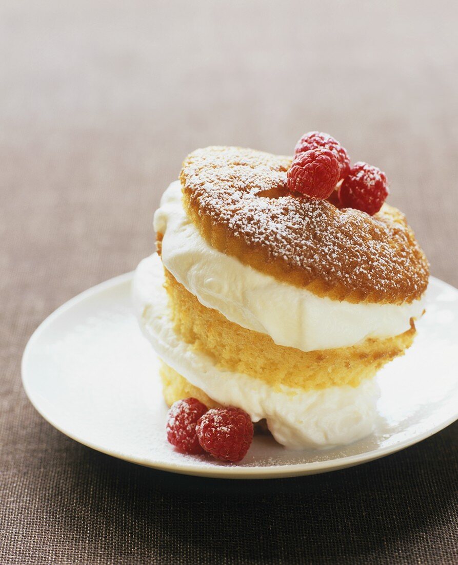 Ein Cupcake mit Sahneeiscreme gefüllt und Himbeeren