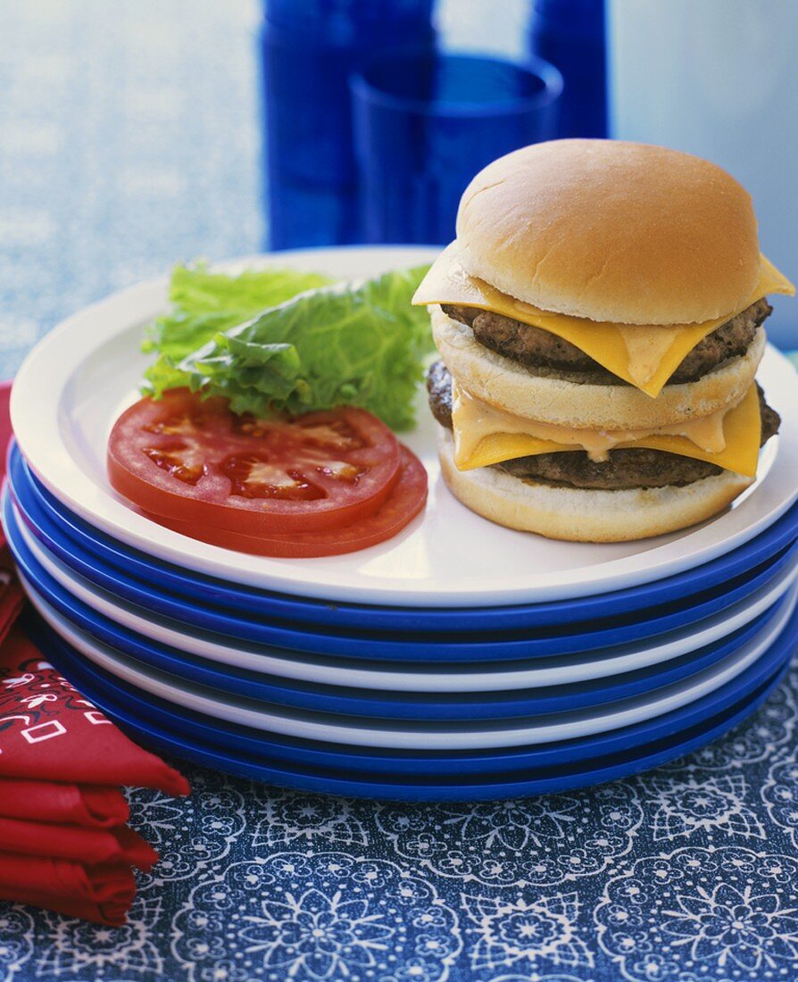 A double cheeseburger with tomato and lettuce