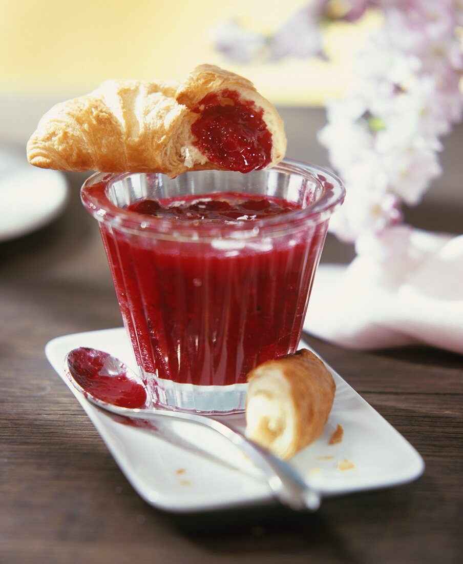 Redcurrant and vanilla jam in a jar with croissant