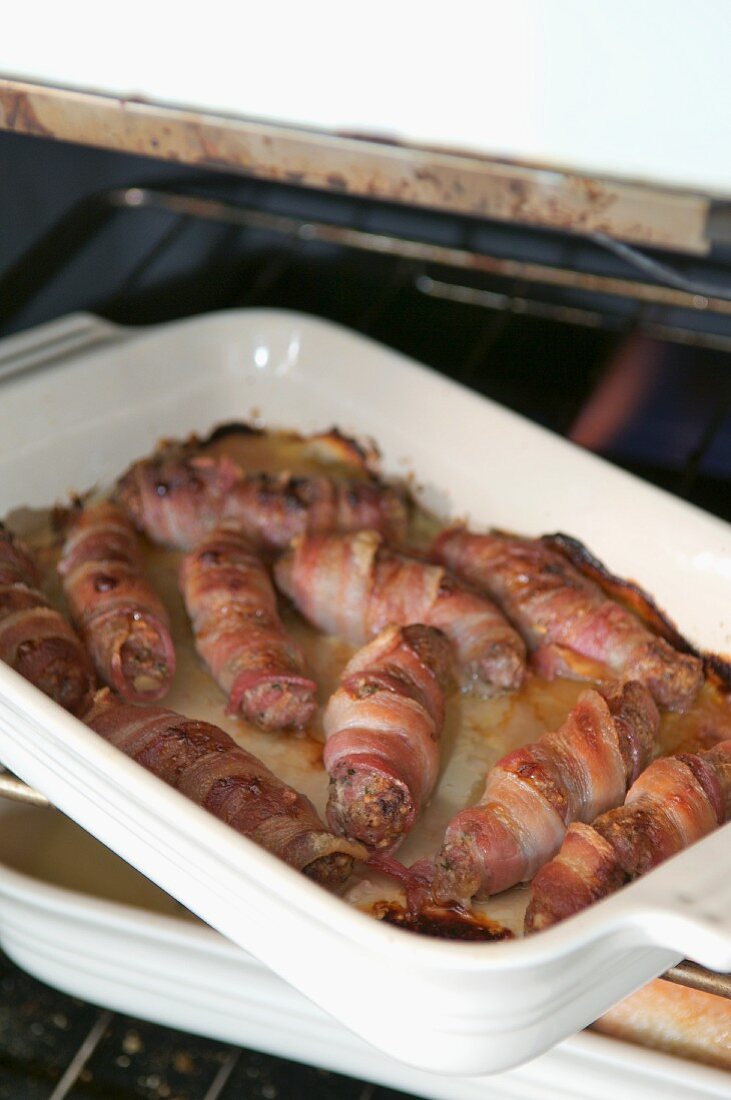 Bacon-wrapped sausages with herbs, apple and nuts