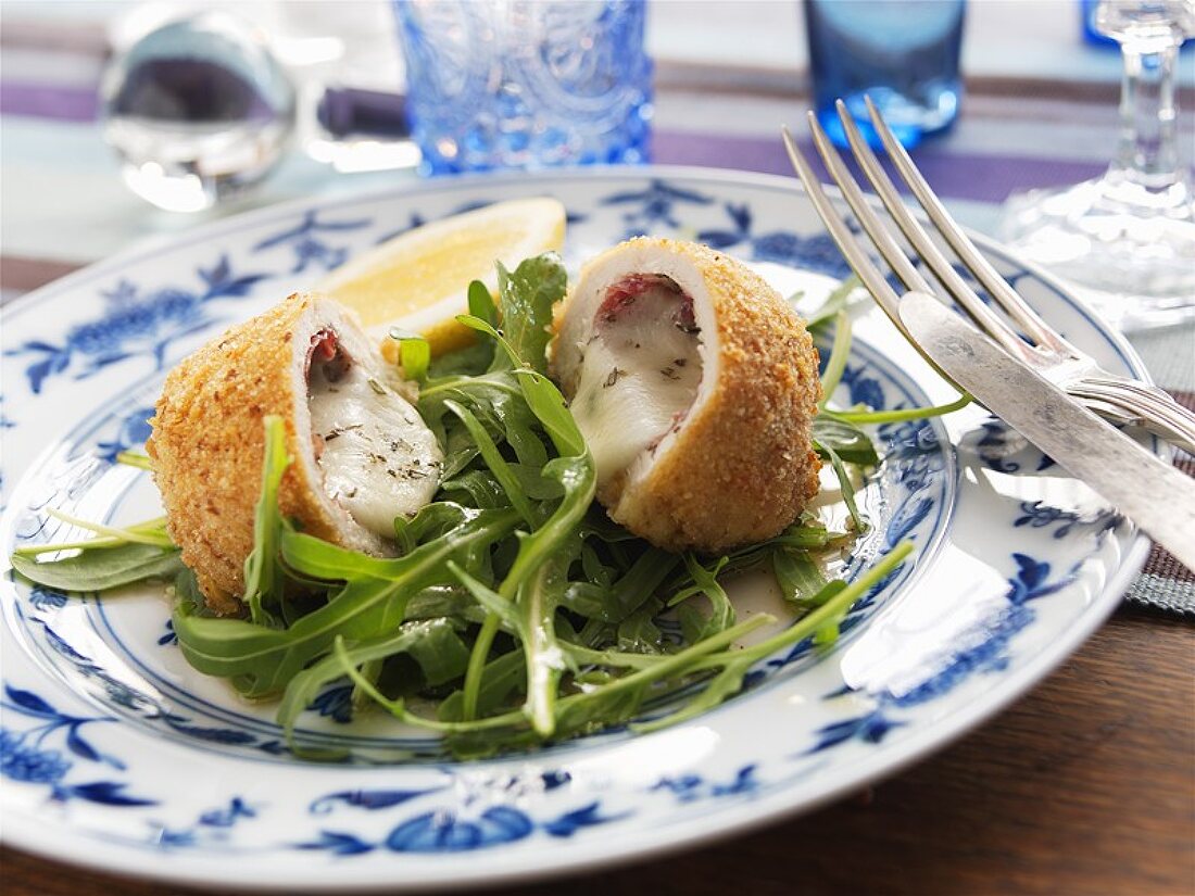 Chicken breast stuffed with bresaola and cheese on rocket