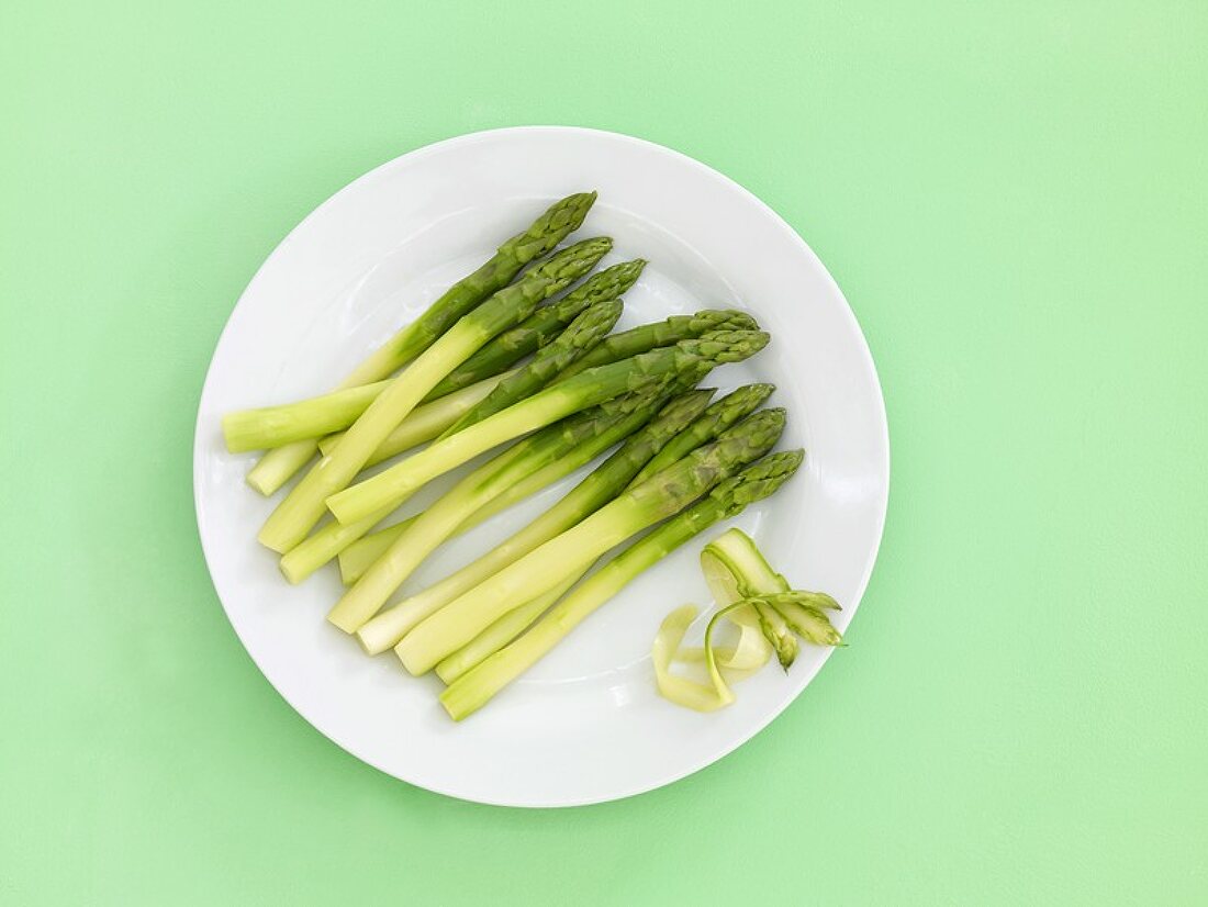 Peeled green asparagus on a china plate