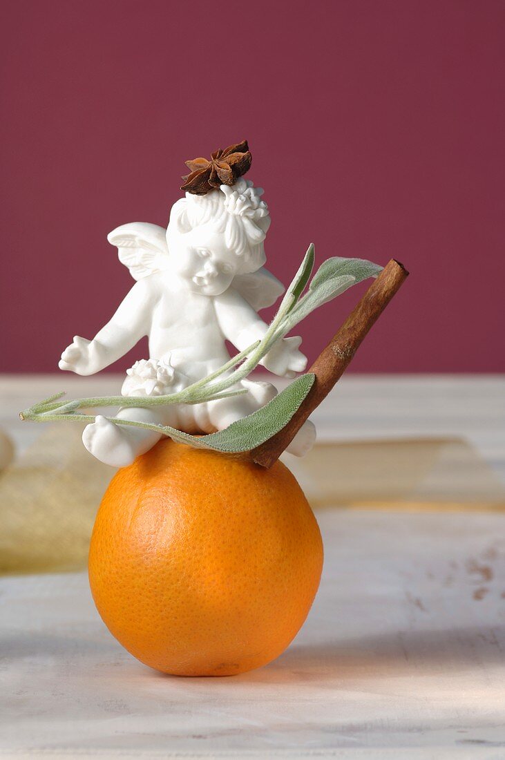 Porcelain angel with cinnamon, star anise & sage on orange