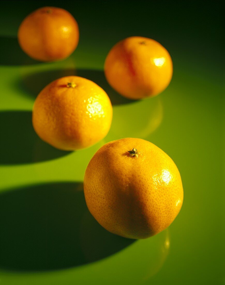 Four Oranges on Green Background