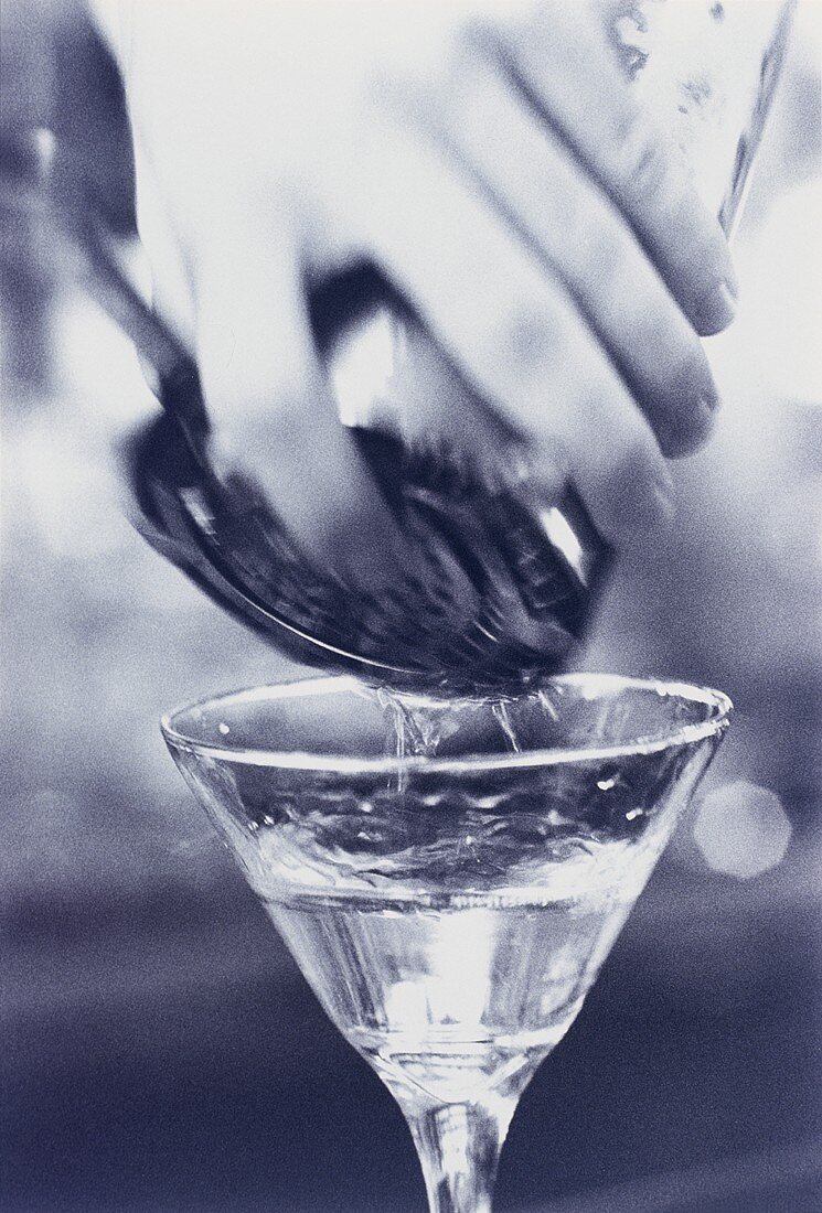 Martini aus Shaker ins Glas einschenken (s-w-Aufnahme)
