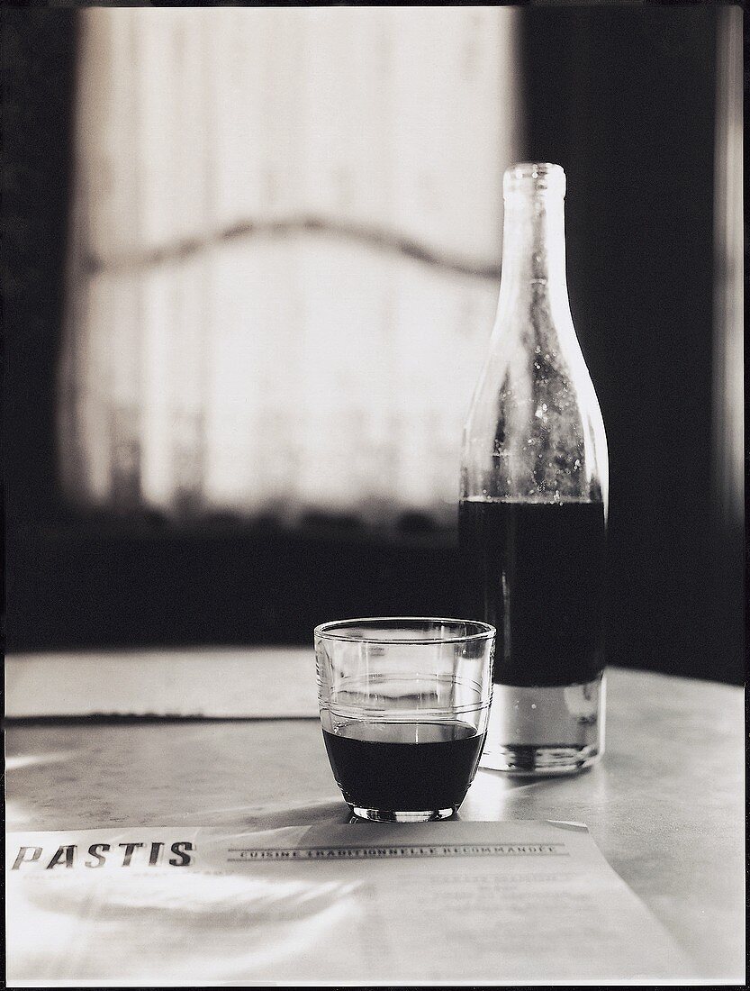 Red wine in bottle & glass on table (Pastis restaurant, USA)