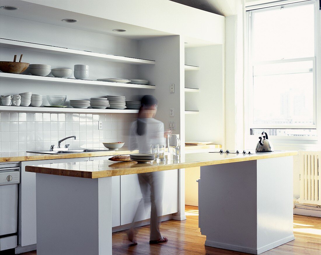Woman walking through a modern kitchen