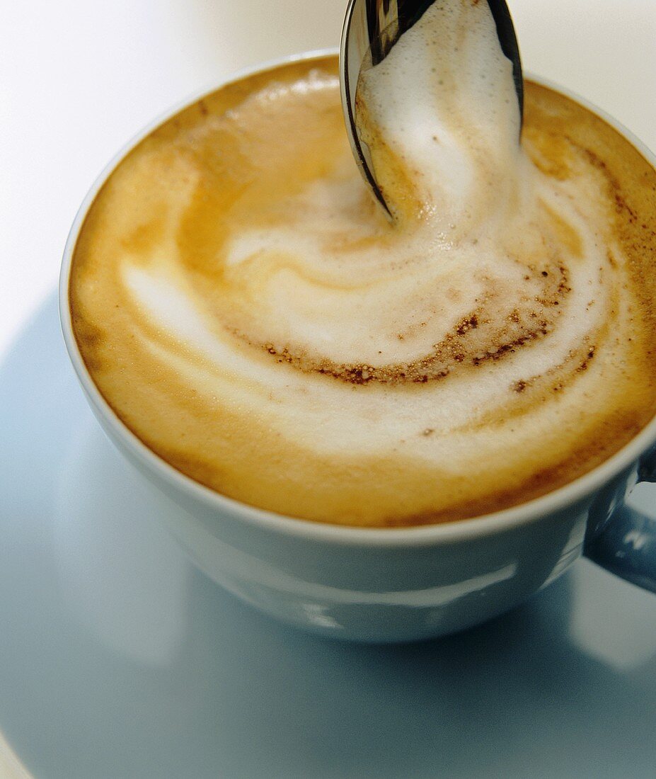 Eine Tasse Cappuccino mit Löffel