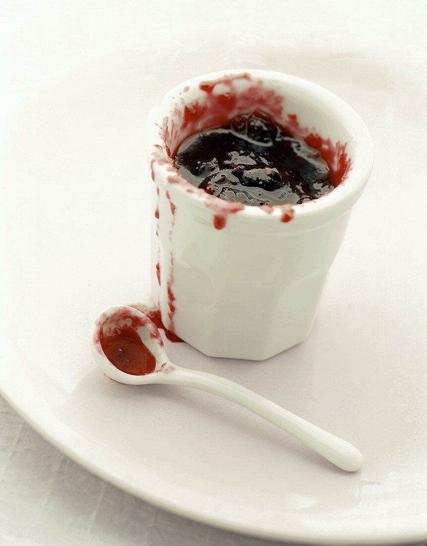 Dish and spoon with red jam