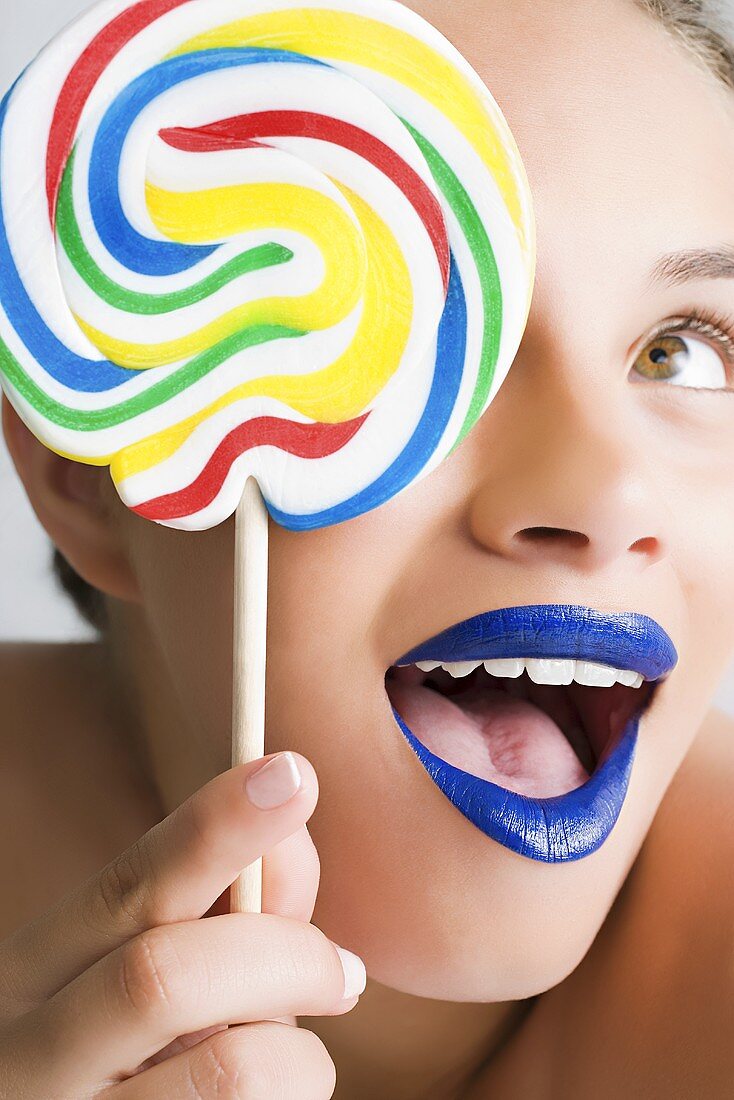 A woman holding a colourful lollipop