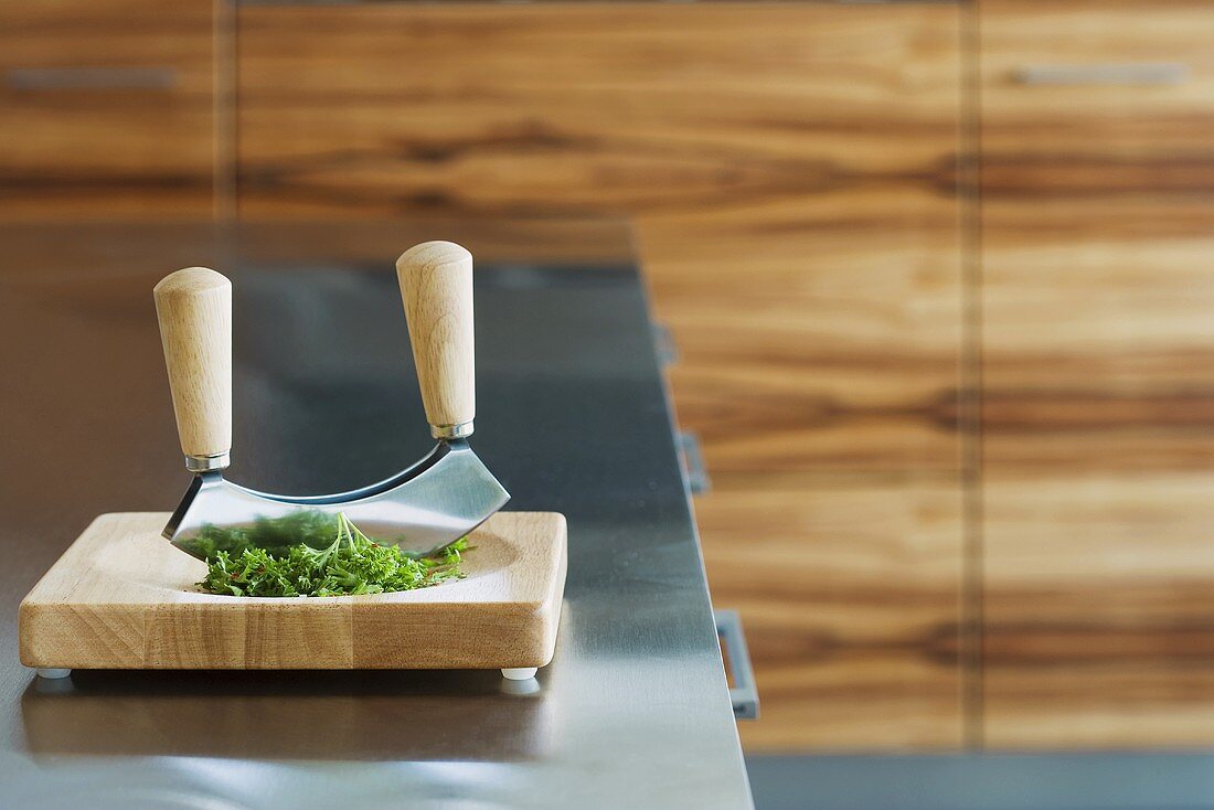 A chopping knife and herbs on a chopping board