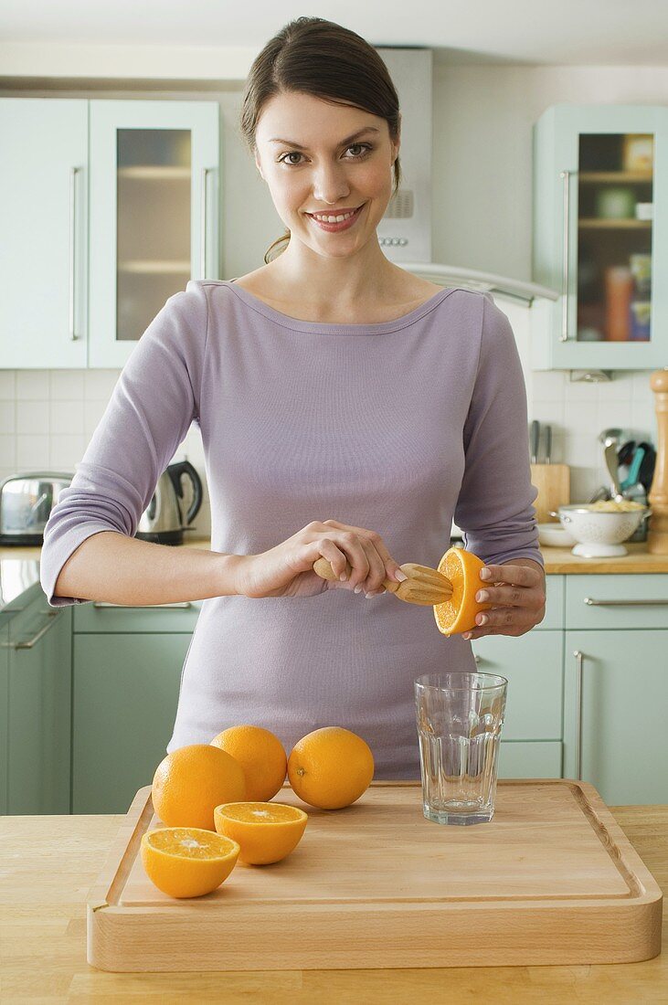 Frau macht Orangensaft