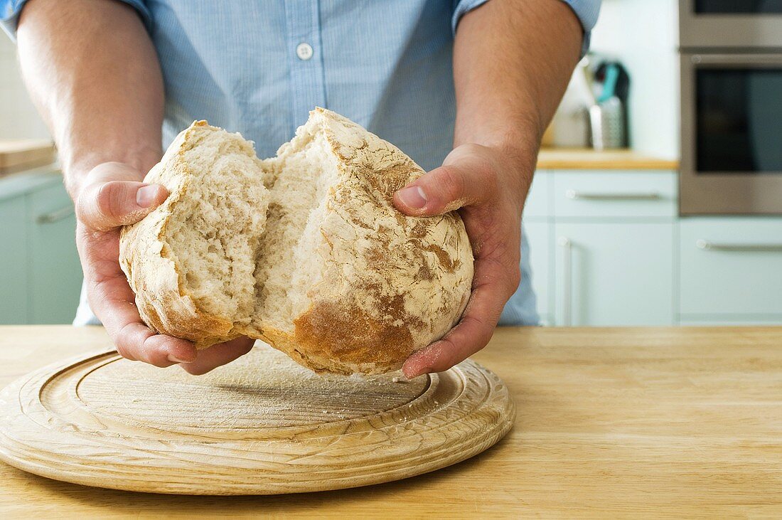 Mann bricht Brot