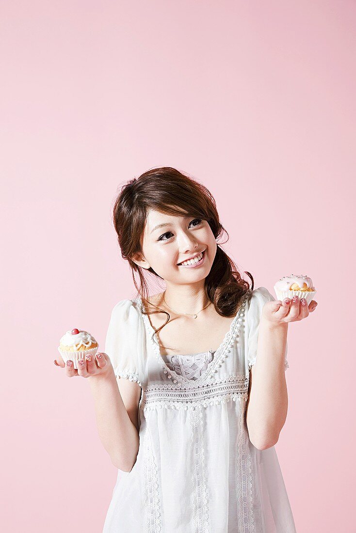 A woman holding cupcakes