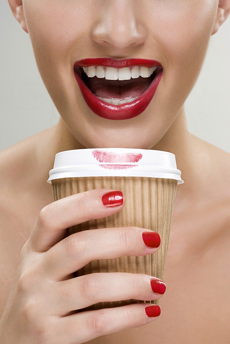 Woman drinking coffee from a paper cup