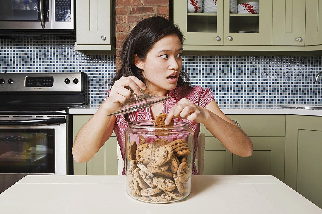 Young woman with cookie jar