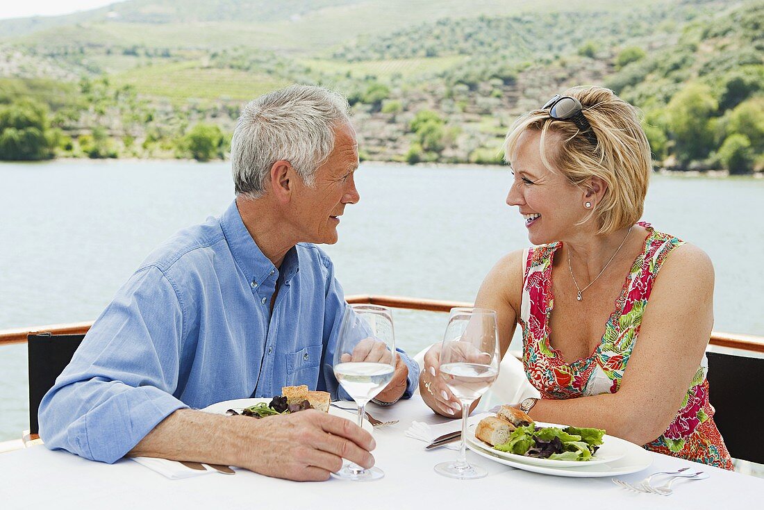 Älteres Paar beim Mittagessen auf einem Boot, Urlaub