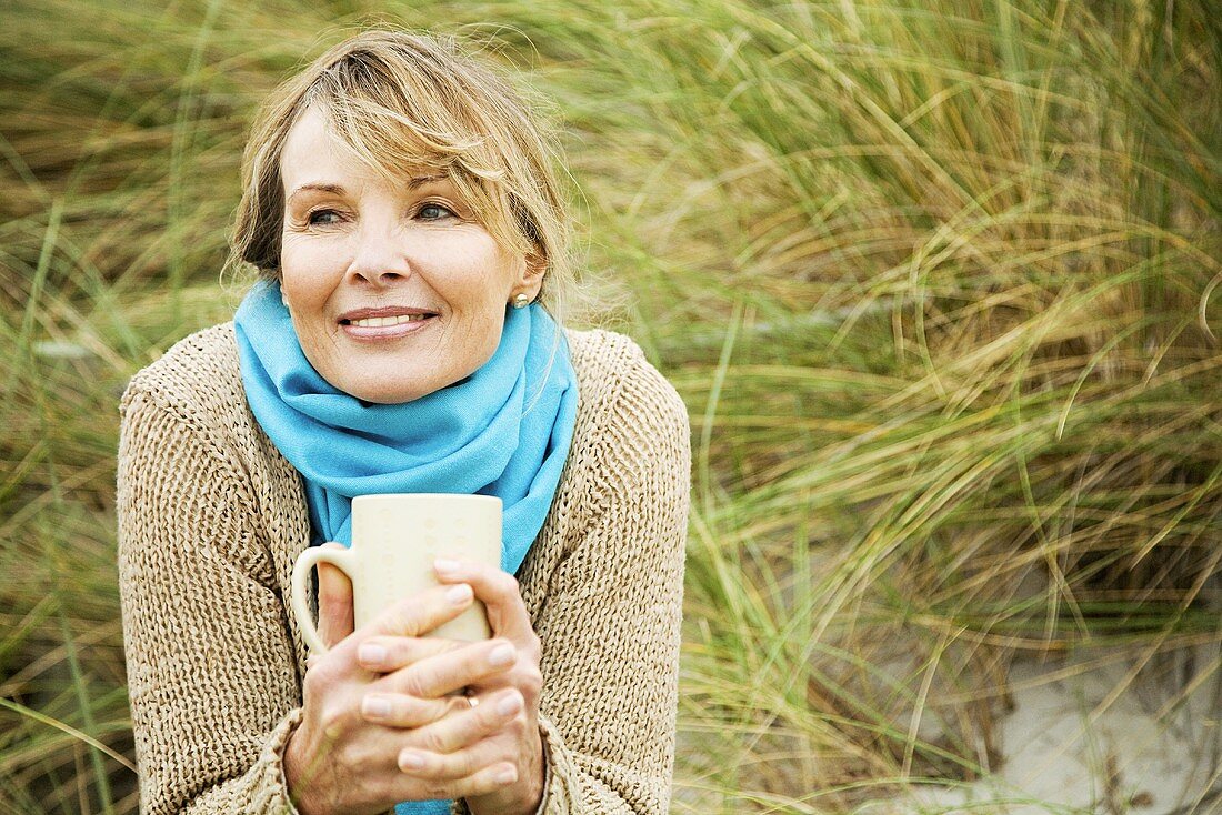 Frau im Freien mit einer Tasse