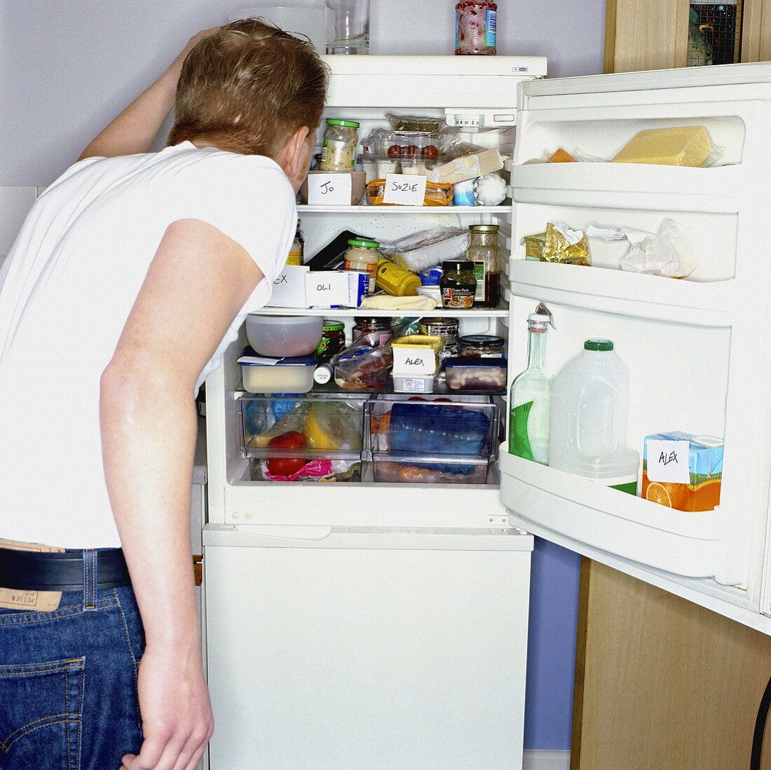 Mann sucht nach Lebensmitteln im Kühlschrank