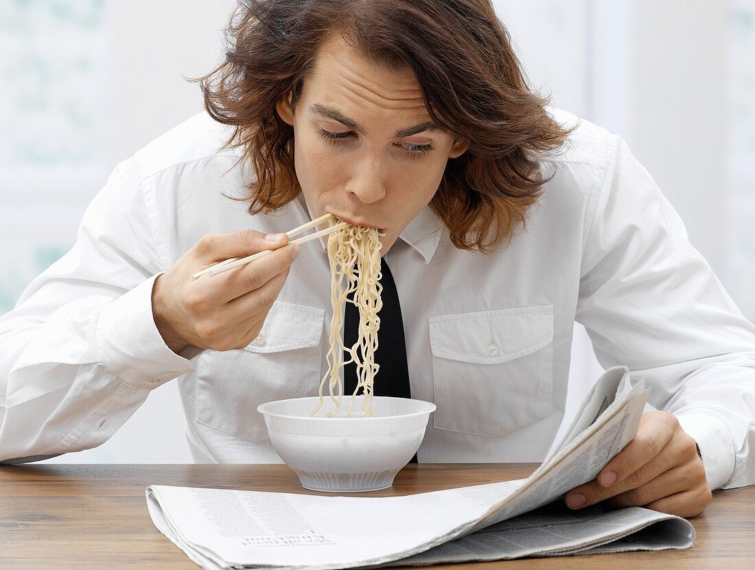 An office worker eating spaghetti