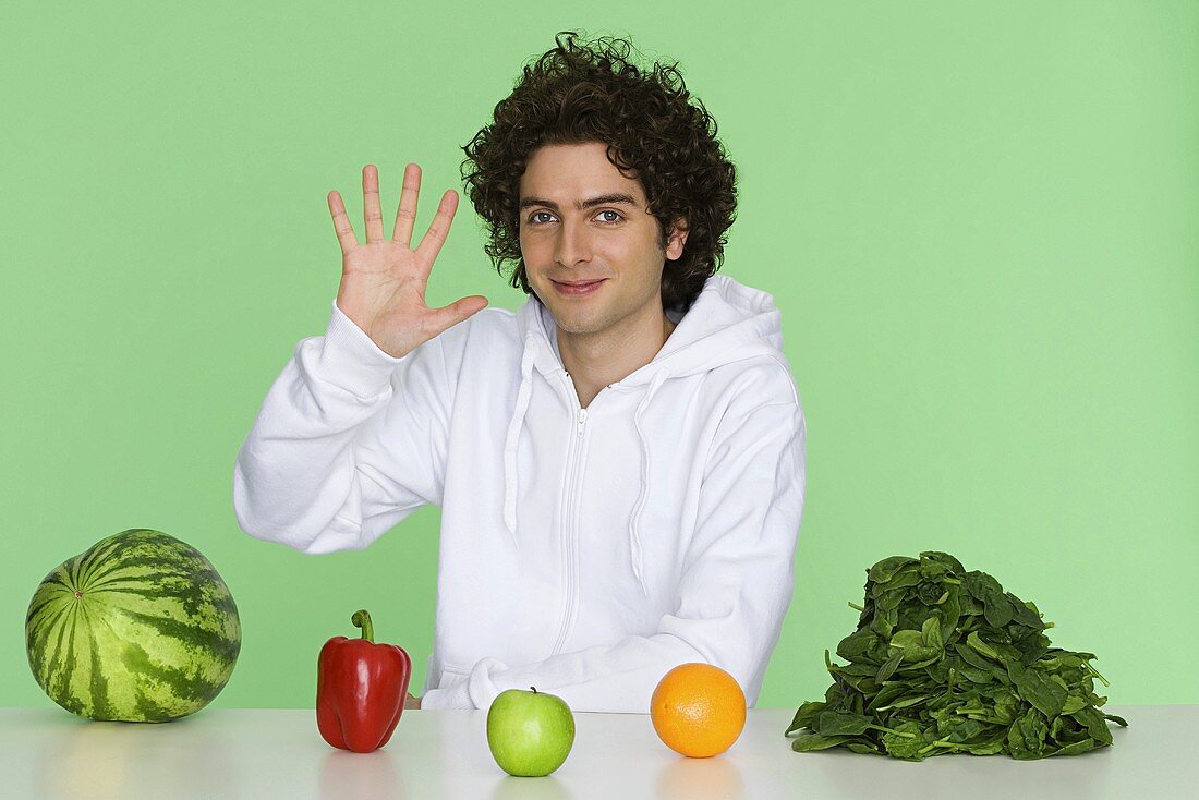 Junger Mann mit Obst und Gemüse