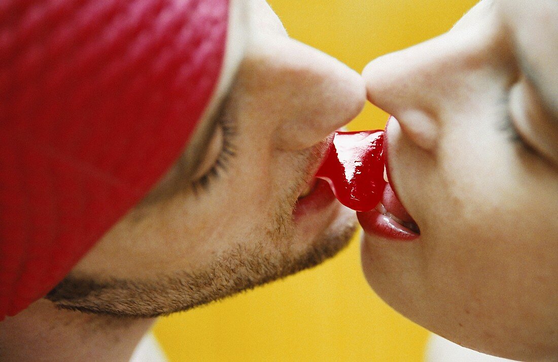 A young couple sharing a heart-shaped sweet