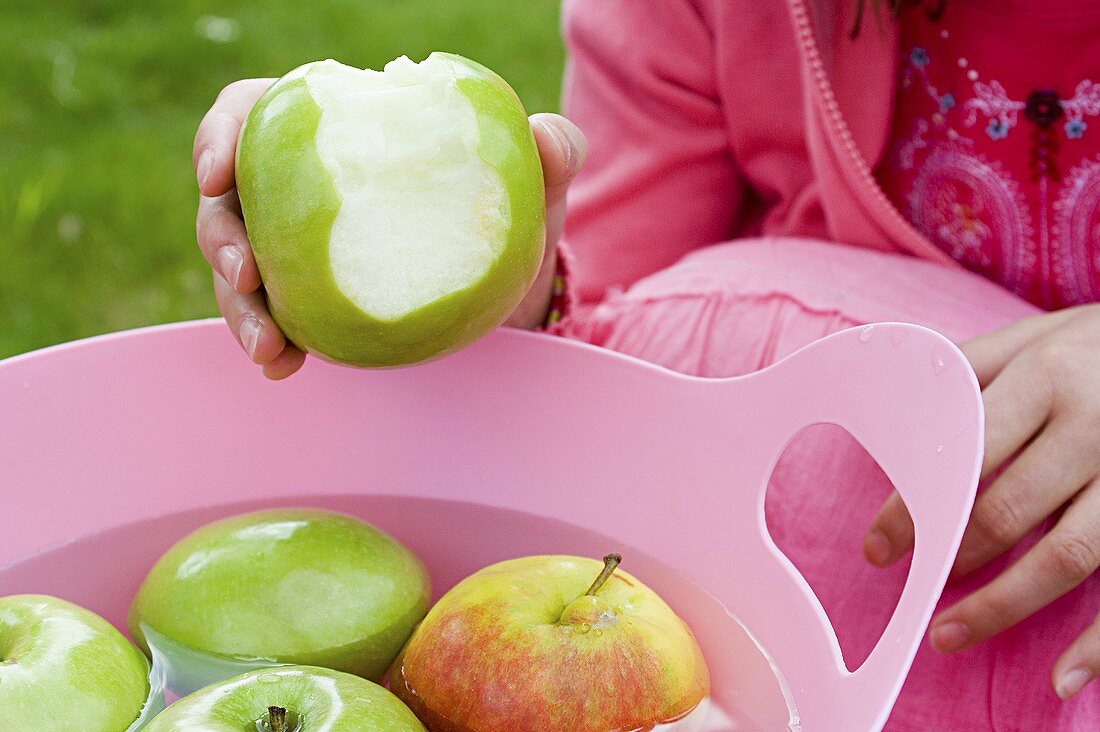 A girl with an apple with a bite taken out