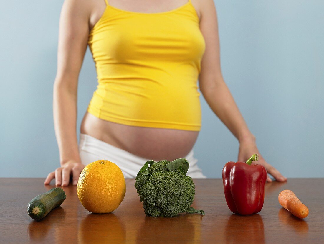 Schwangere Frau mit Obst und Gemüse