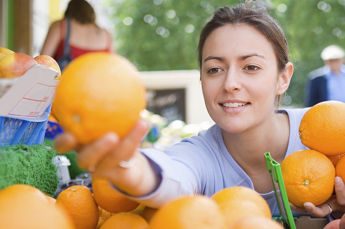 A woman choosing oranges