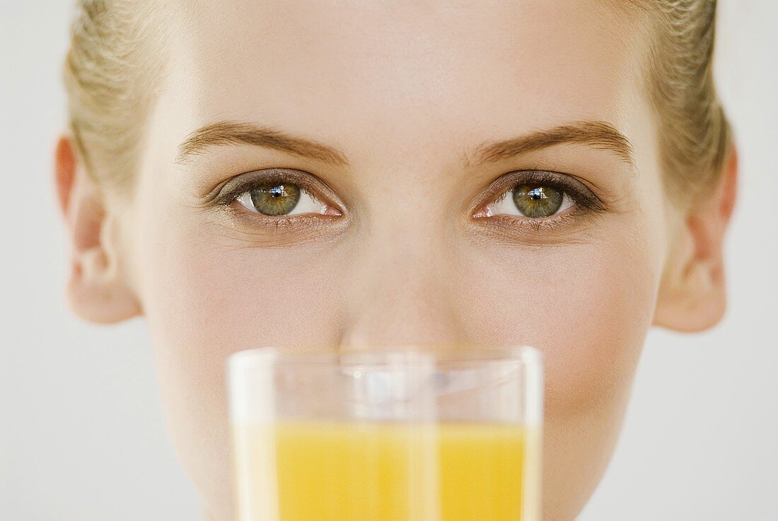 Junge Frau trinkt ein Glas Orangensaft