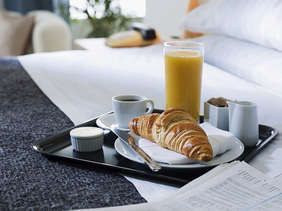 A breakfast tray on a hotel bed