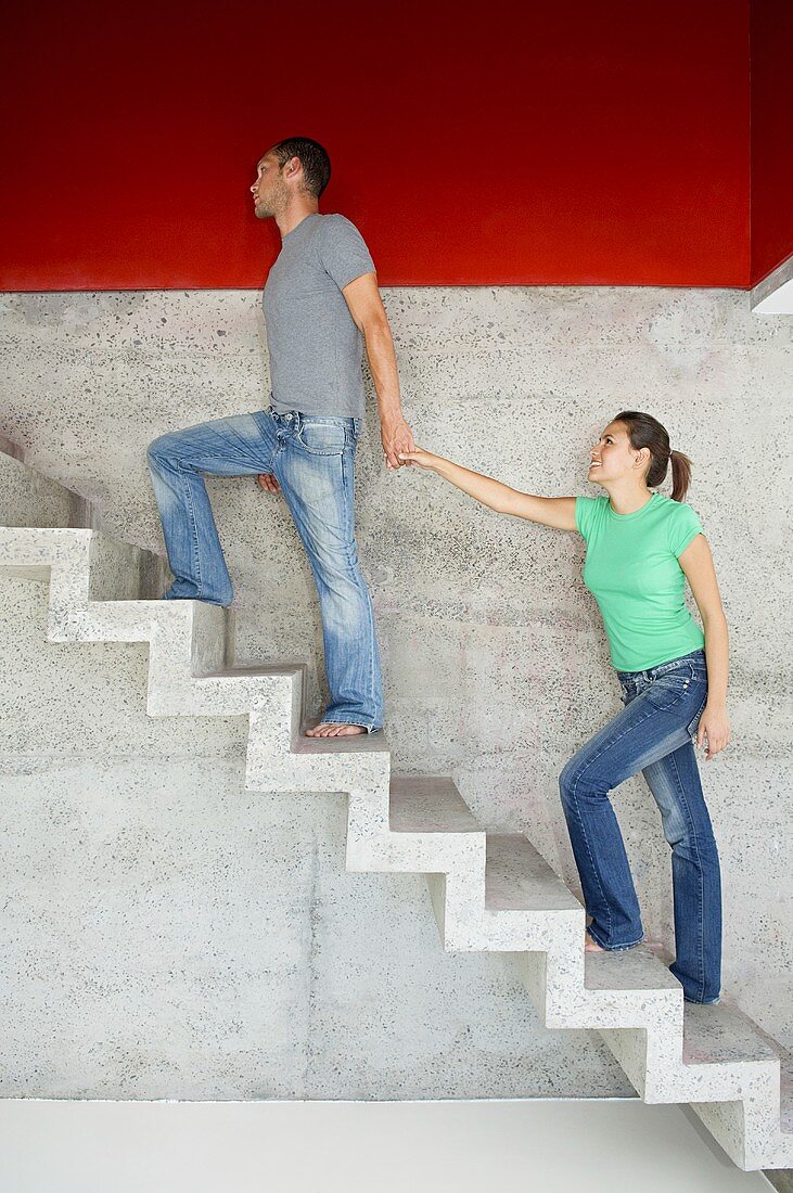 A man leading his girlfriend upstairs