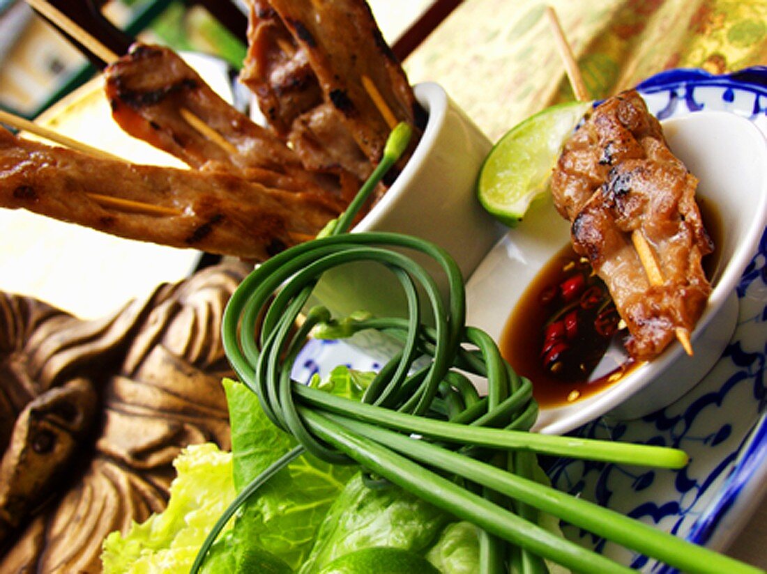 Thai satay in bowls with soy and chili sauce