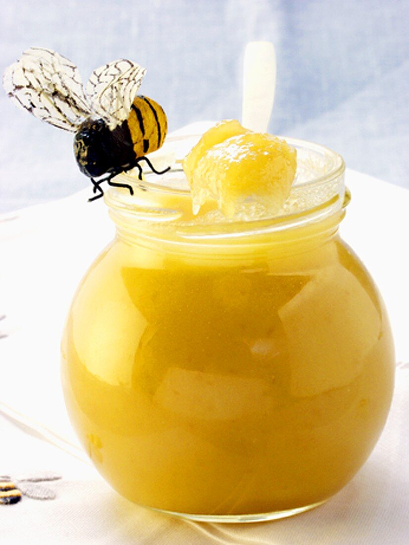 Blossom honey in jar and on spoon; bee