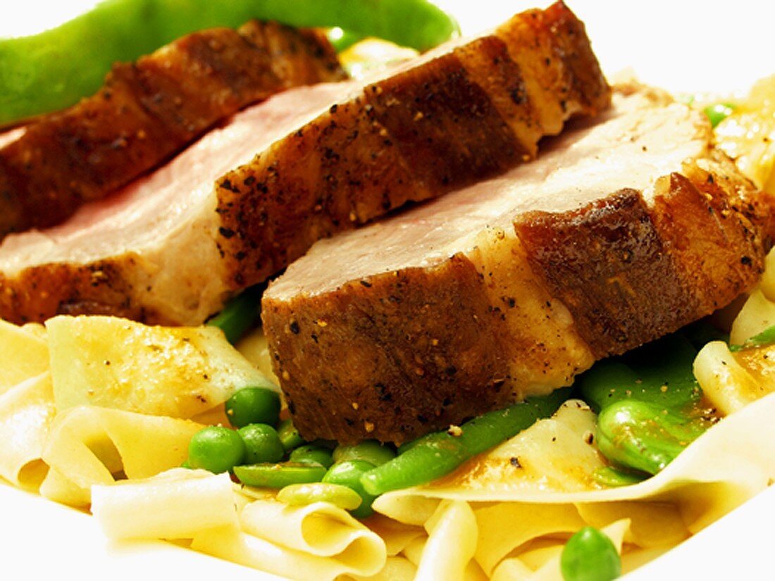 Roast pork with noodles, beans and peas