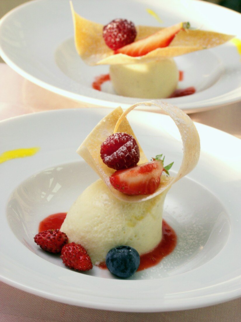 Yoghurt mousse with fruit sauce, garnished with berries