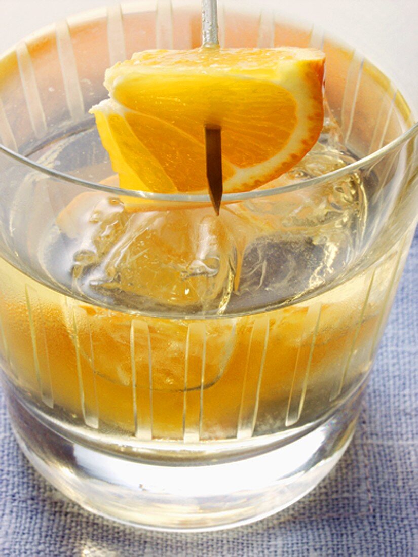 Cocktail mit Orange und Eiswürfeln