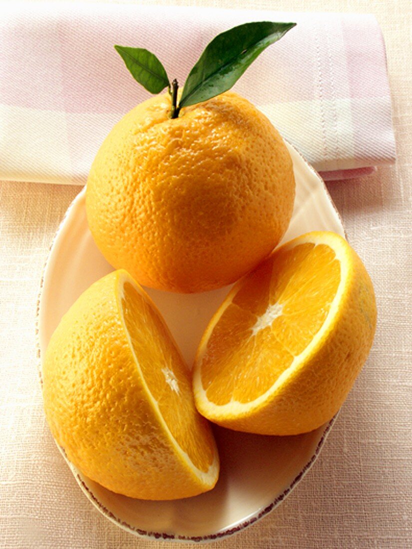 Orange and orange halves on plate