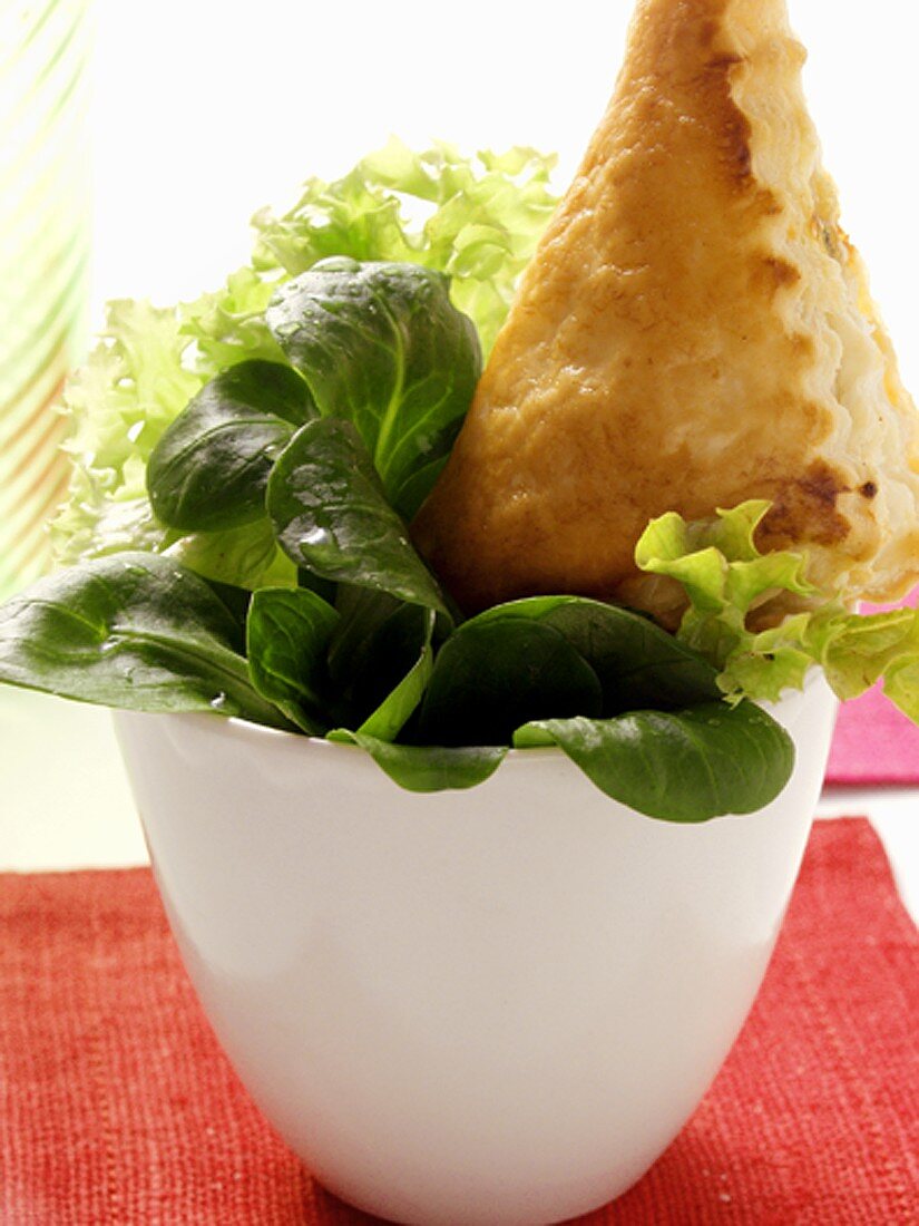 Small mixed salad with pastry parcel in bowl