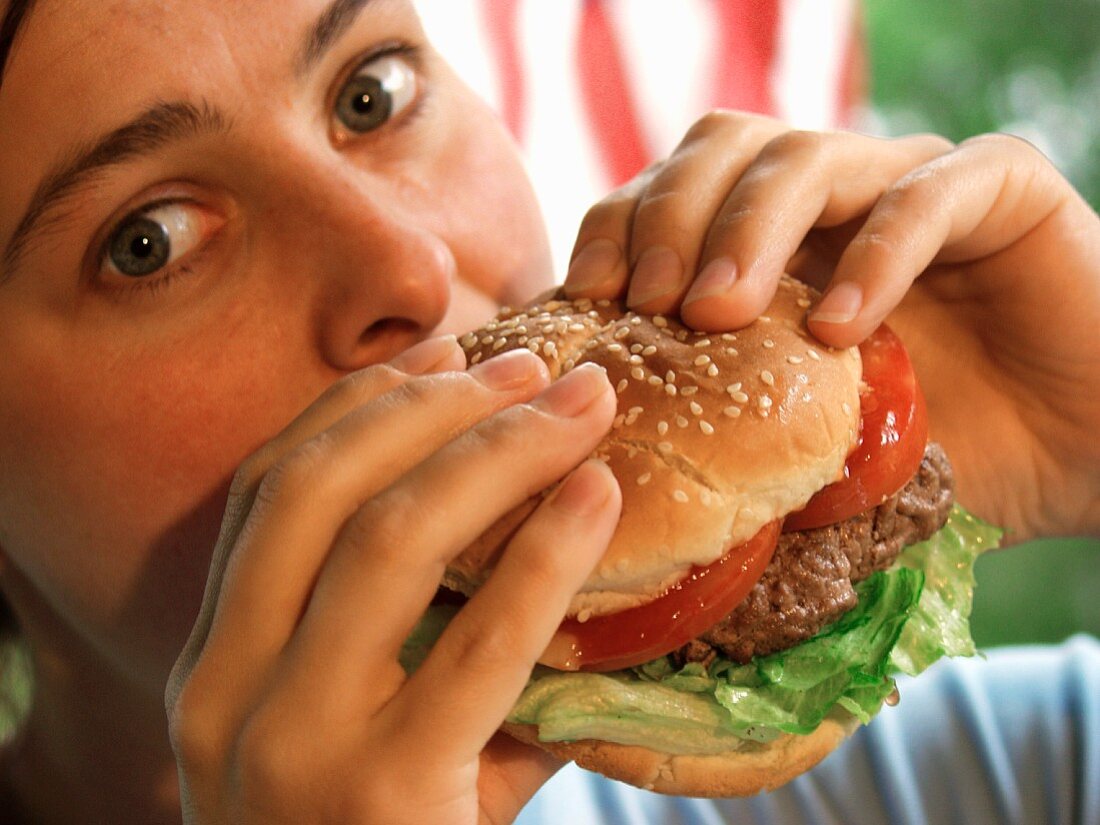 Girl eating succulent hamburger