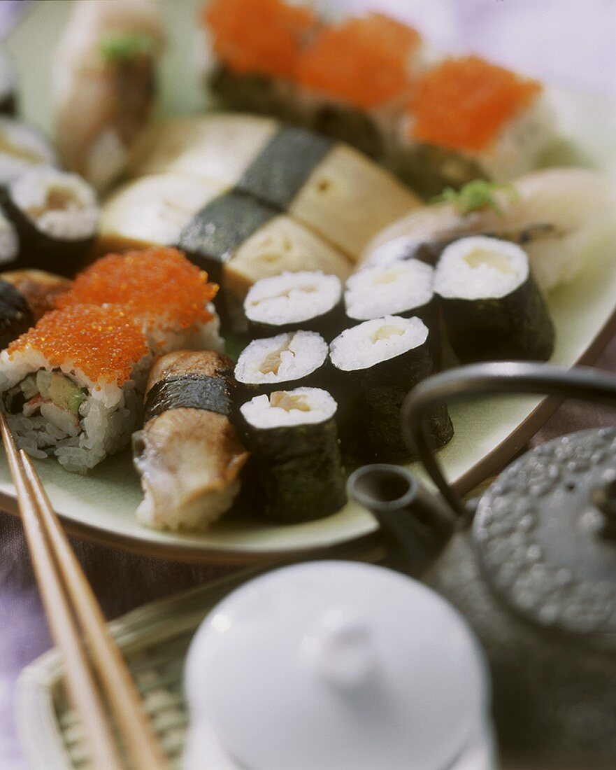 Verschiedene Nigiri-Sushi und Maki-Sushi; Teekanne